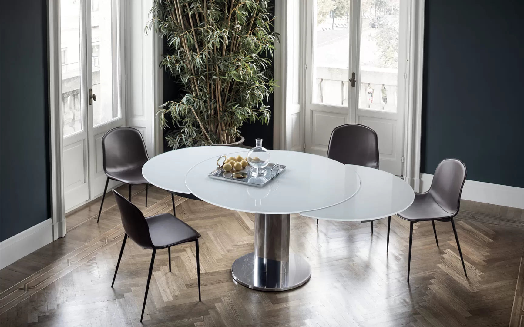 Giro Round extending table with base in stainless metal and elliptical column in stainless Steel or lacquered Metal